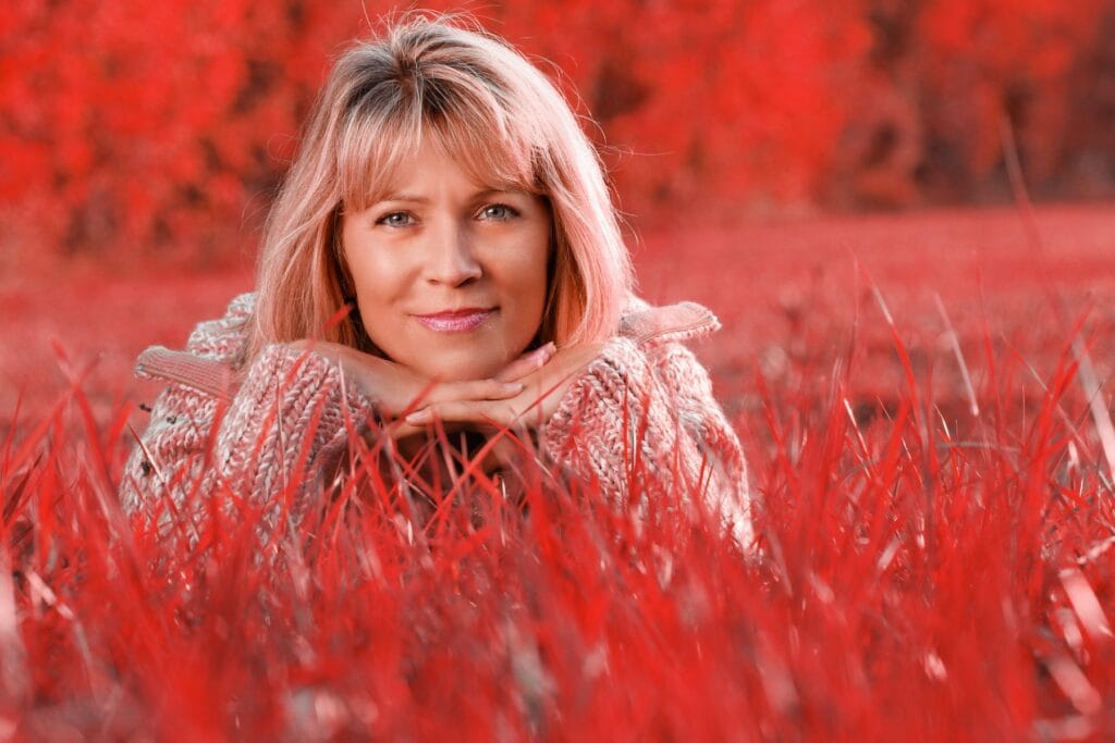 Attractive,Mature,Woman,Lying,Relaxed,In,Grass,In,Autumn